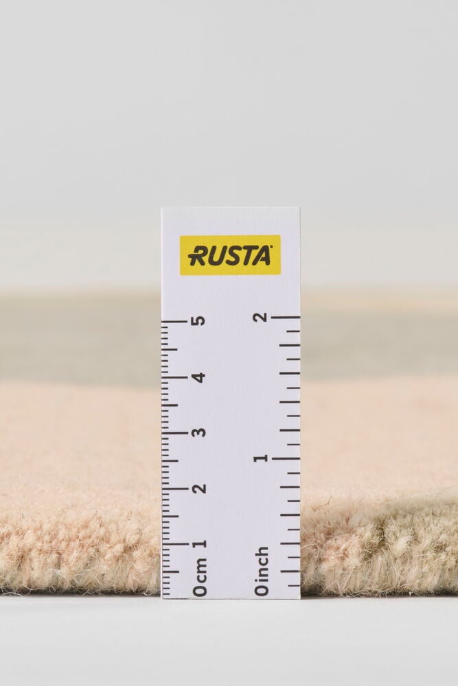 Lähikuva sivukuva monivärisestä Villamatosta Field, jonka paksuutta viivain mittaa.