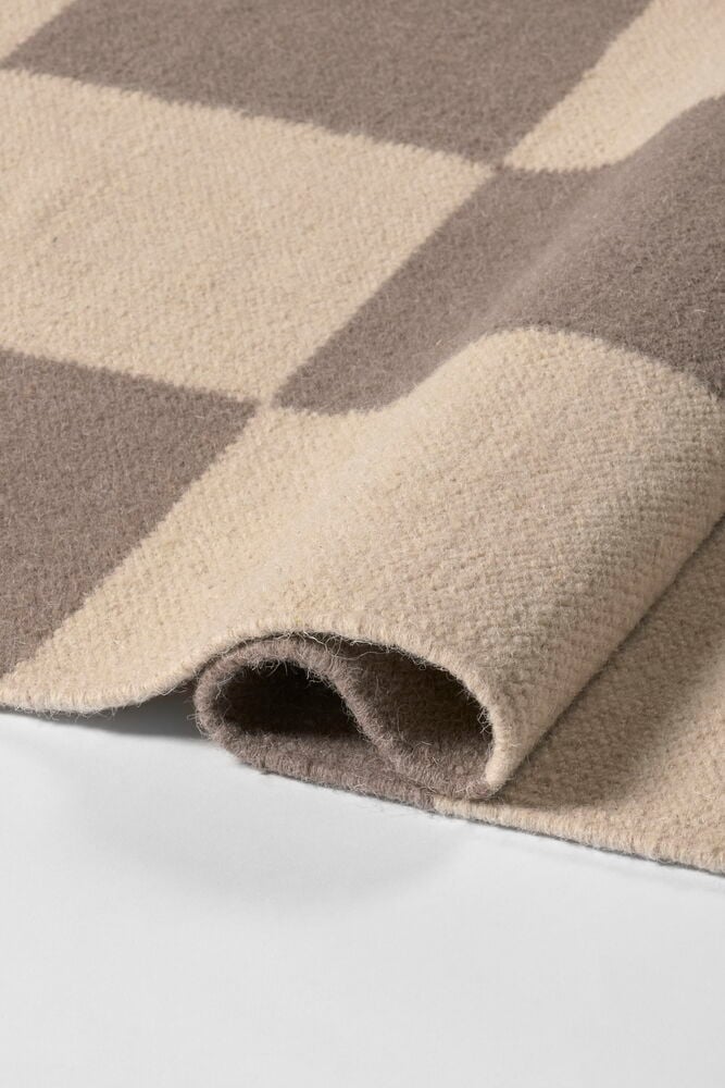 Vikt ullmatta Elsaform Rutan med grått och beige rutigt mönster, närbild.