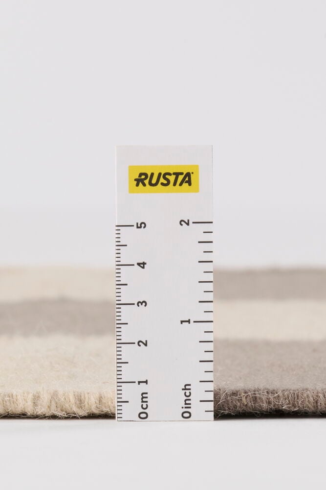 Närbild sidovy av en Grå Ullmatta Elsaform Rutan, randig, som visar dess 1,5 cm lugghöjd.