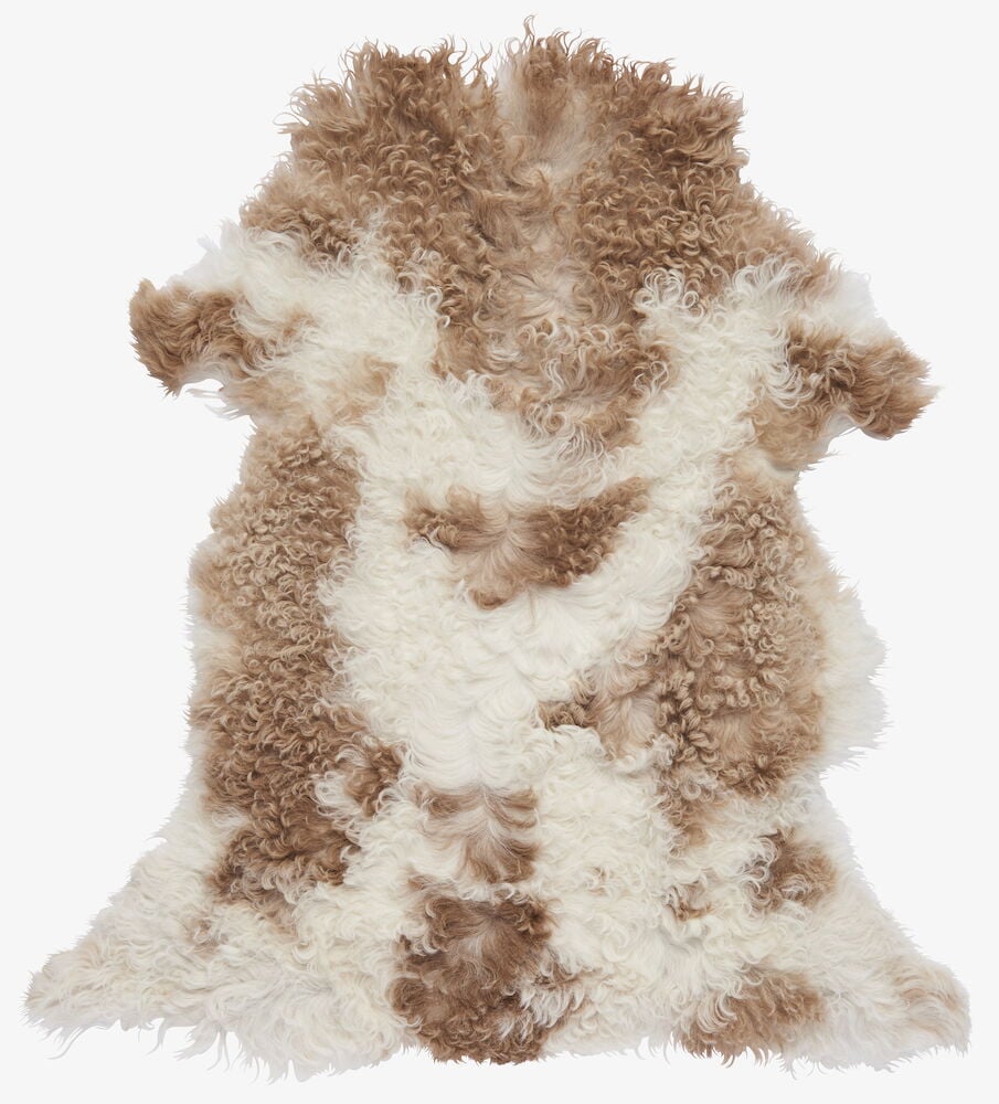 Brunt och vitt lockigt fårskinn i blandade färger.