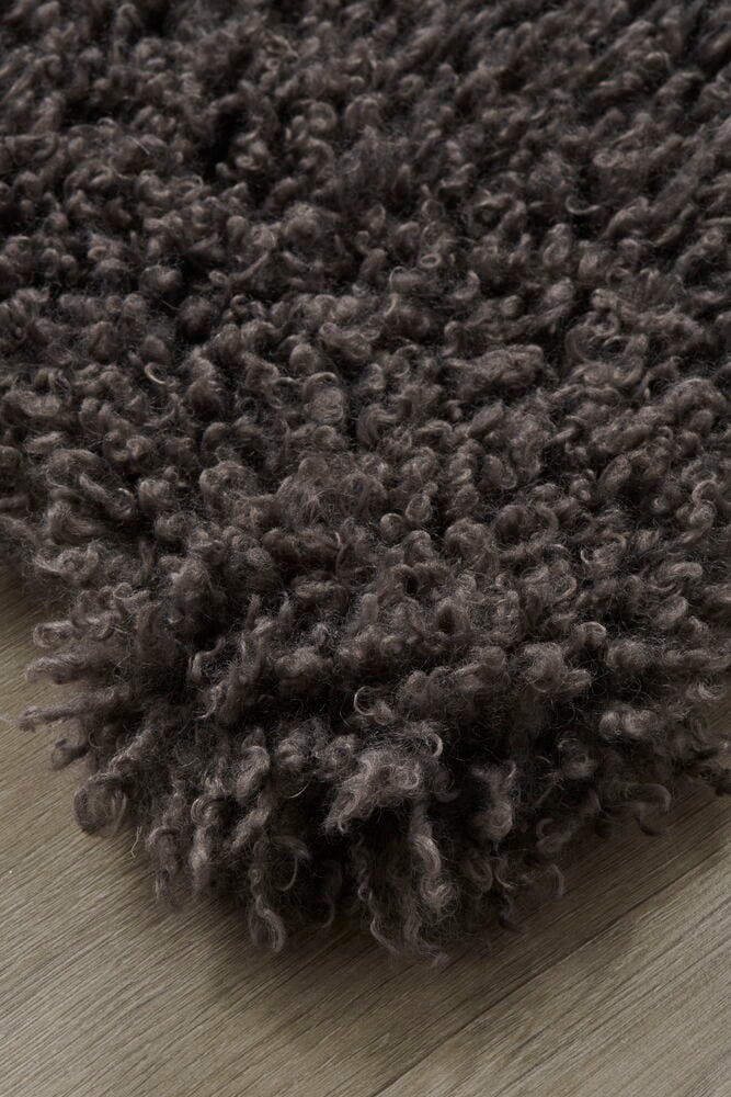 Grå konstfäll med lockig yta på trägolv.