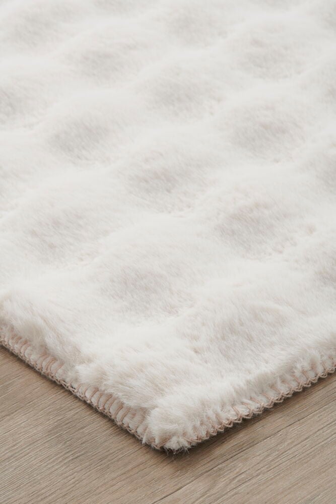 Ljusbeige fluffig matta med mjuk tuftad yta.