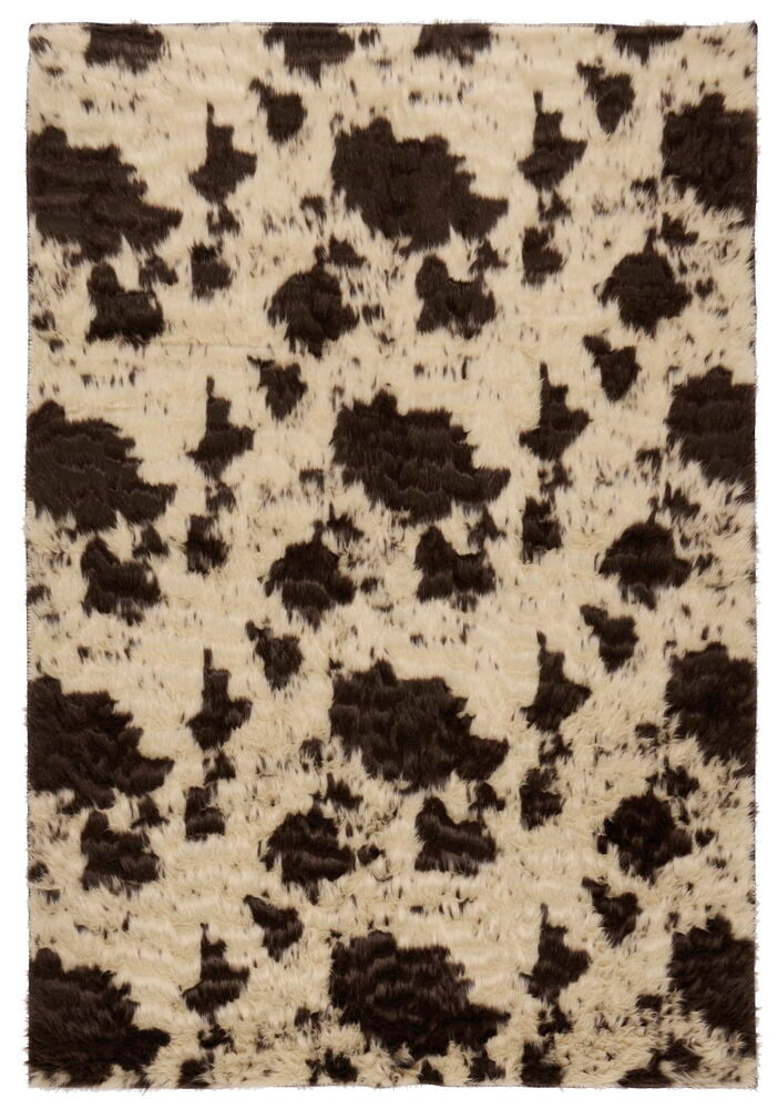 Rektangulært fuskepelsteppe med brunt og beige ku-mønster, laget av polyester.
