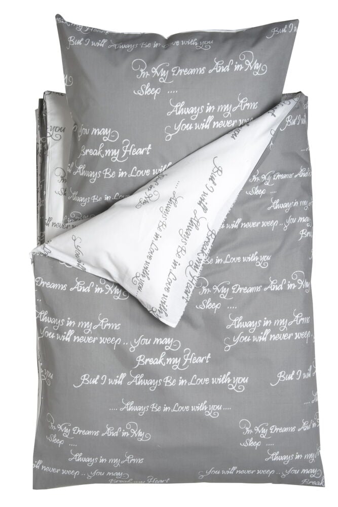 Harmaa pussilakanasetti, jossa valkoinen teksti puuvillaa.