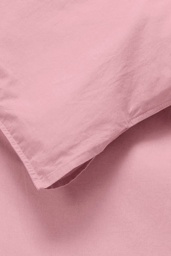 Gammelrosa påslakanset i bomull på närbild.