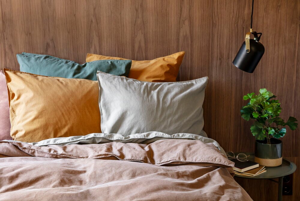 Bettwäsche-Set Vida 135x200 cm Braun Baumwolle mit braunem Bettbezug, senfgelben, teal- und hellgrauen Kissen.