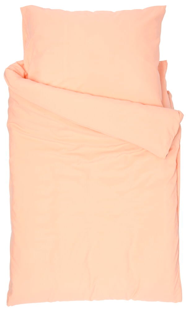 Pussilakanasetti pehmeässä persikanvärissä valkoisella taustalla.