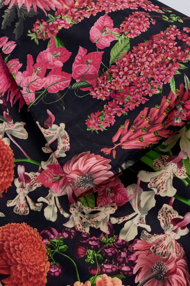 Bäddset med färgglatt blommönster på mörk botten.