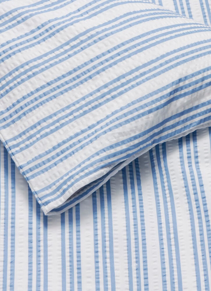 Blau-weiß gestreiftes Bettwäscheset aus Baumwollstoff.