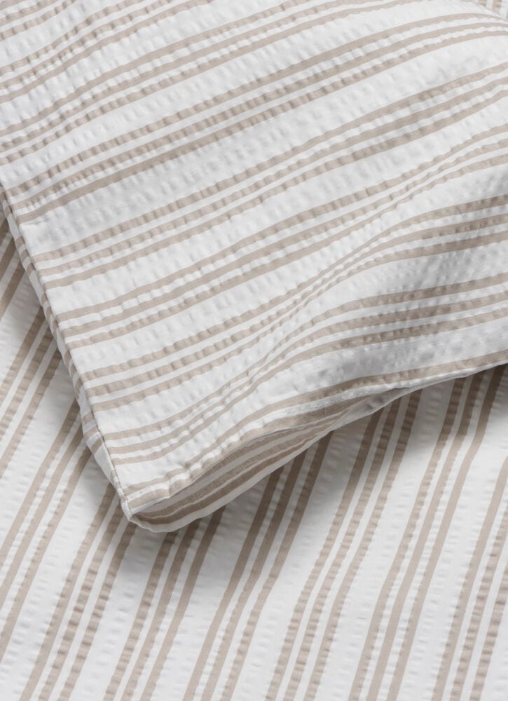 Beigen ja valkoraitainen seersucker-pussilakanasetti puuvillasta.