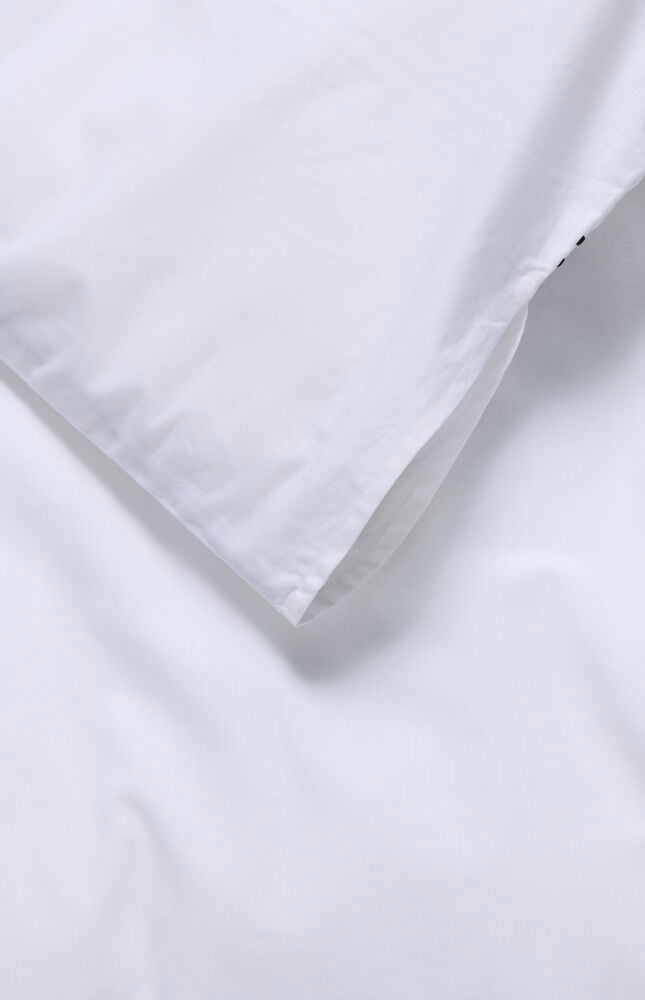 Nahaufnahme eines weißen Bettwäsche-Sets Hotel Collection aus Baumwolle, das die Deckenbezugsöffnung zeigt.