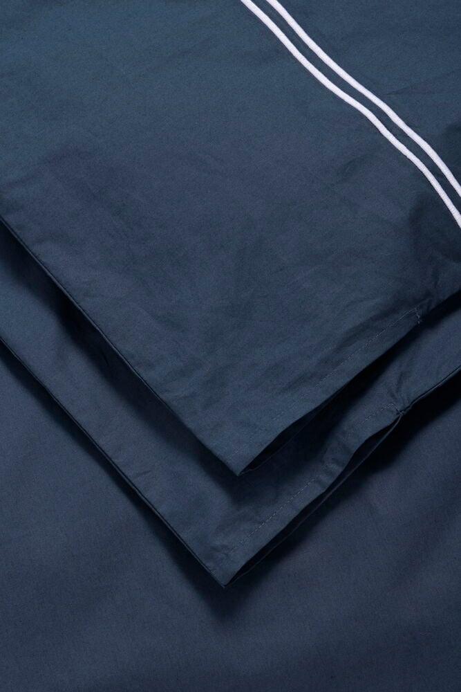 Gefaltetes marineblaues Baumwoll-Bettwäsche-Set, Hotel Collection, mit zwei weißen Streifen.