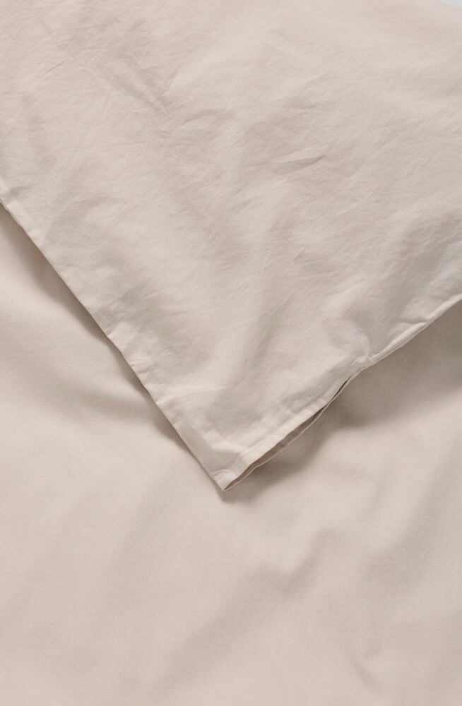Närbild av ett beige Påslakanset Elsaform, visar ett vikt påslakan med synliga veck.