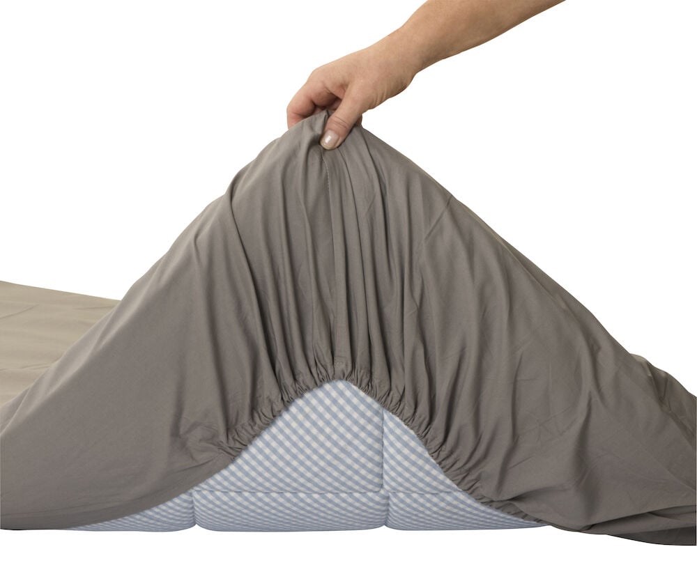 Grått dra på lakan med resår på madrass.