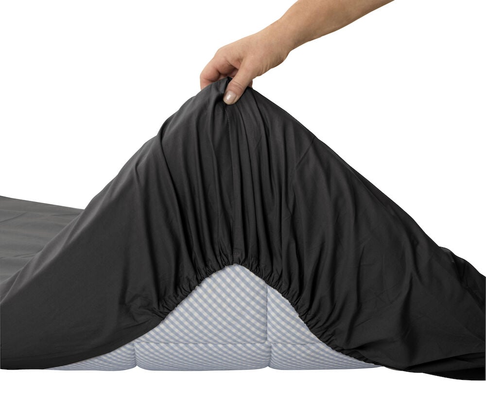 Hand sätter på antracit dra-på-lakan på madrass.