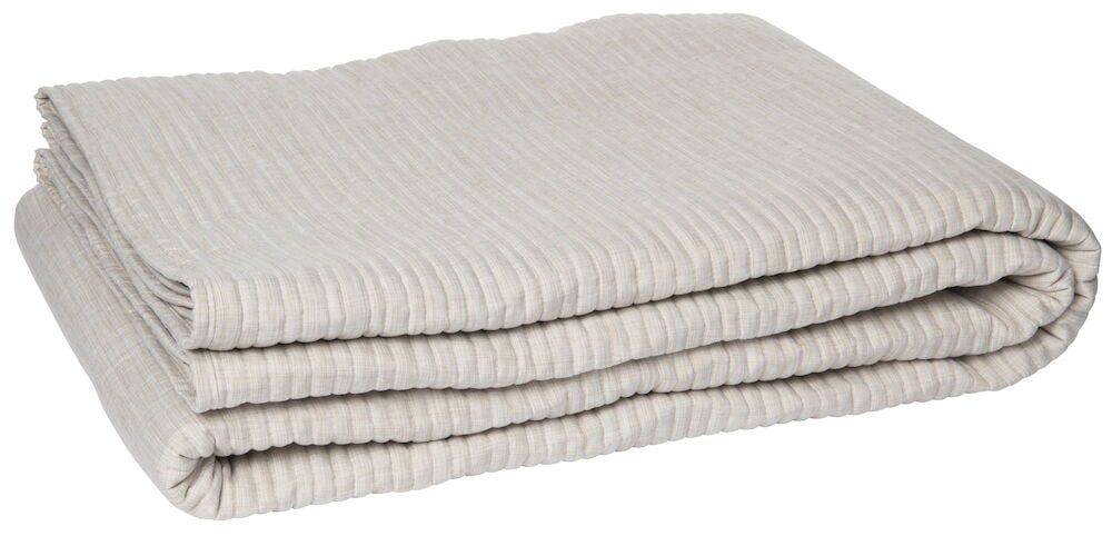 Vikt beige överkast med räfflad yta.