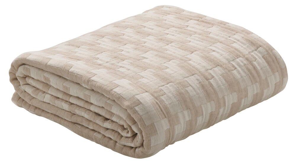 Vikt beige överkast med diskret rutmönster.