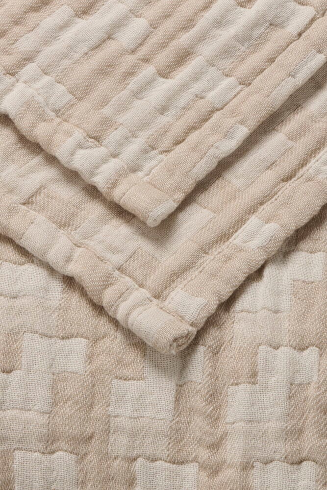 Beige överkast med diskret rutmönster i bomull.
