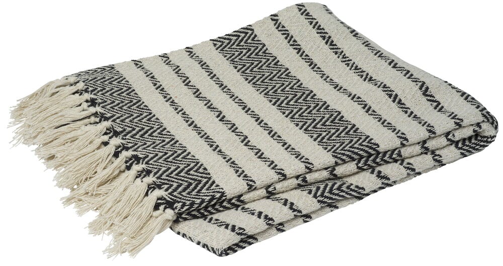 Eine gewichtige offwhite Decke mit schwarzen Mustern.