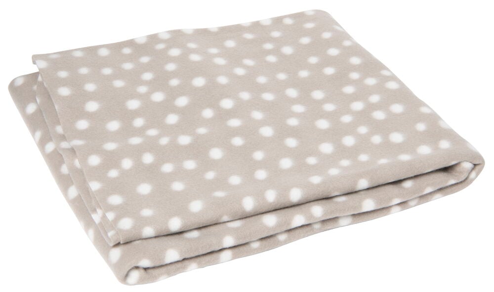 En vikt beige pläd med vita prickar.