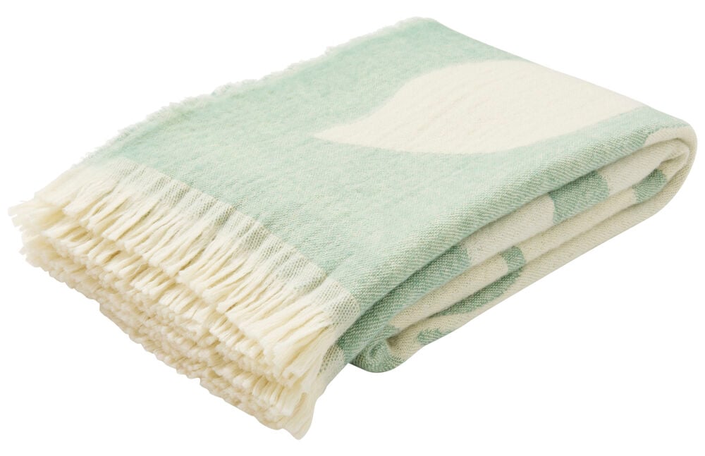 Vikt grön ullpläd med fransar och bladmönster.