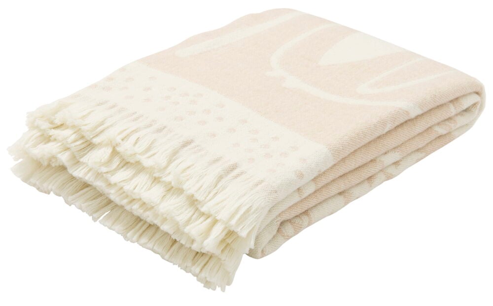 En vikt ullpläd med ljust skogsmotiv och fransar.