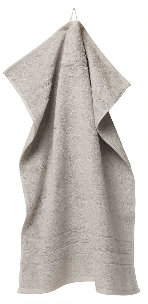 En silverfärgad handduk i kammad bomull upphängd.