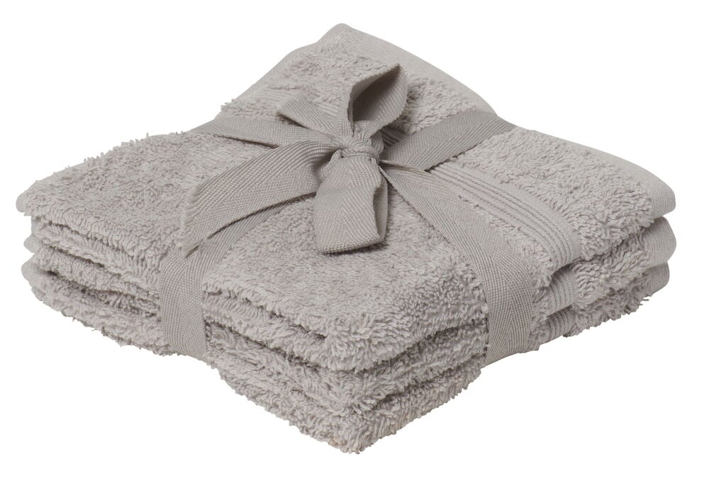 Drei gefaltete silberfarbene Waschlappen mit Schleife.