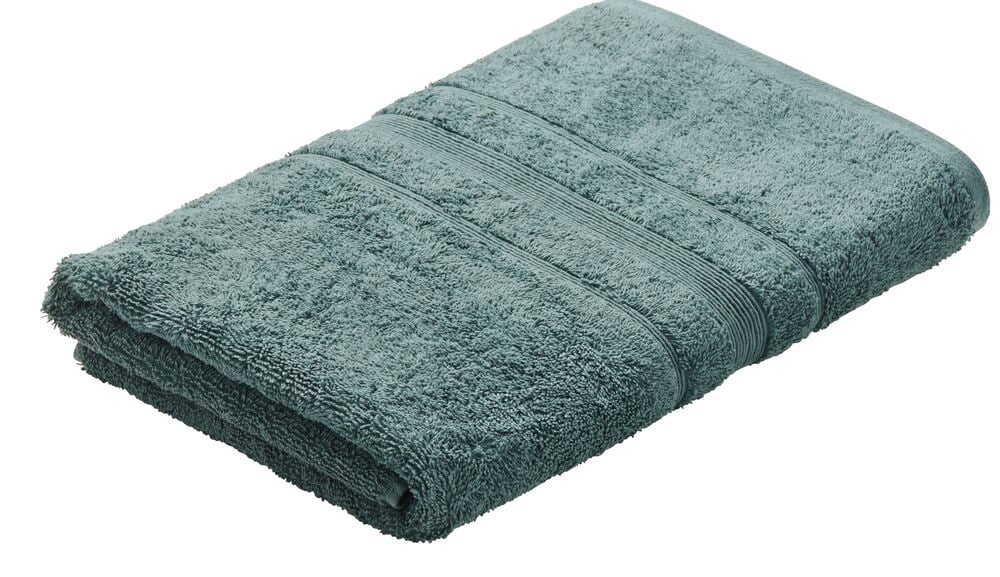 En vikt grön handduk i frottétextur.