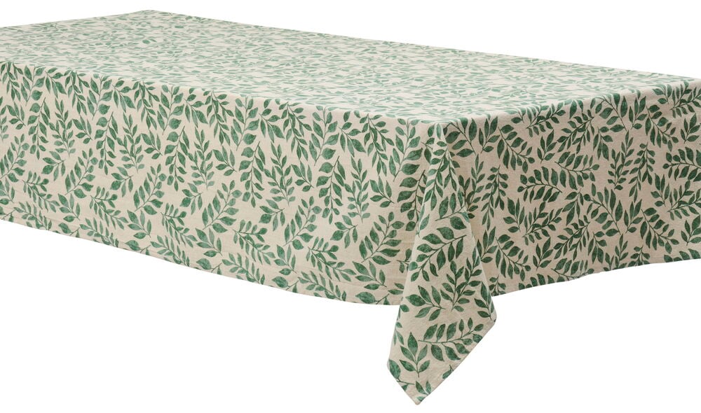 Vihreäkuvioinen puuvillakangas, jossa lehtikuvio pöydällä.