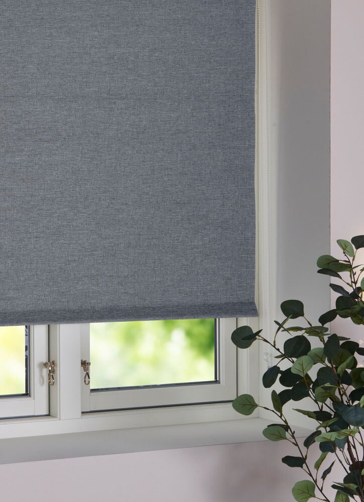 Tummanharmaa rullaverho ikkunan edessä.