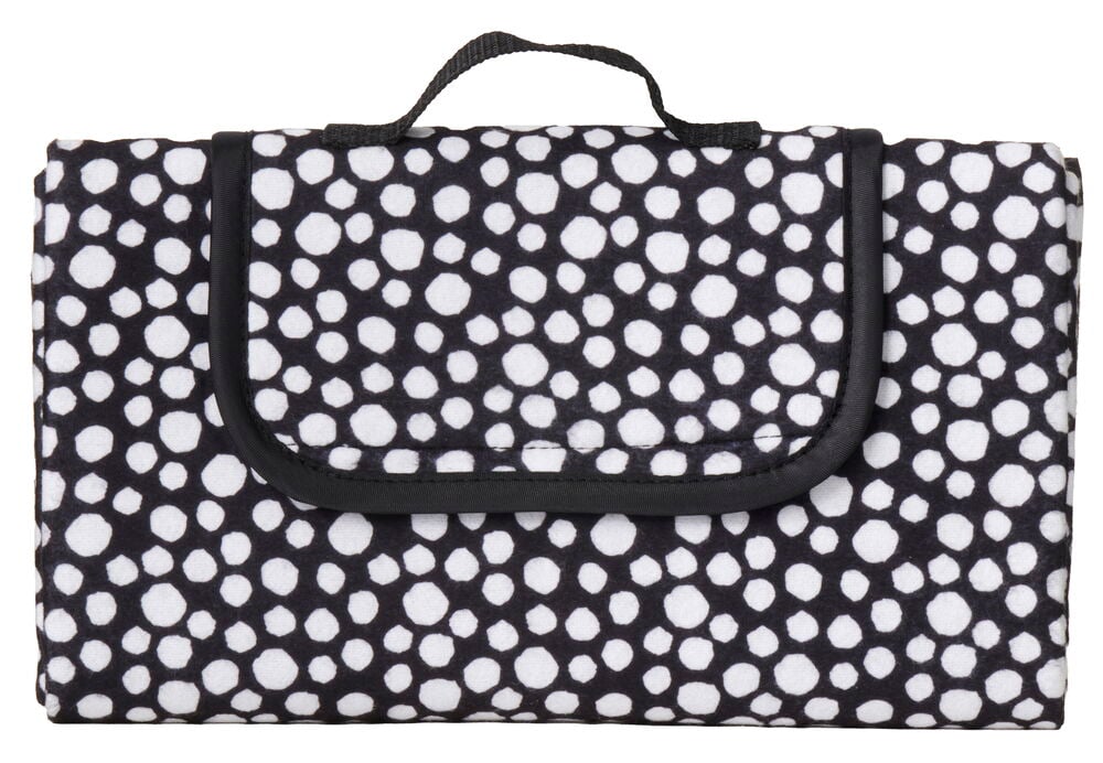Vekt piknikteppe med svarte og hvite prikker.