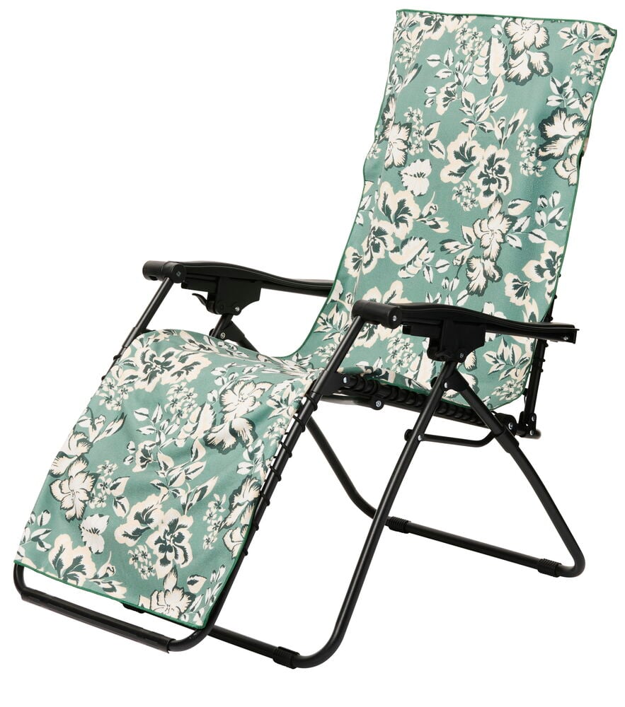 Grønnblomstrete håndkle på svart solstol med armlene.