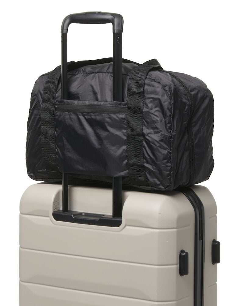 Svart duffelbag ovanpå beige resväska.