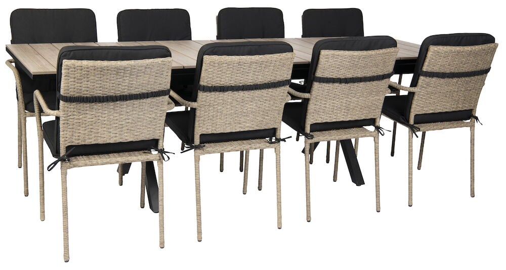 Svart utdragbart bord med åtta rottingstolar och dynor.