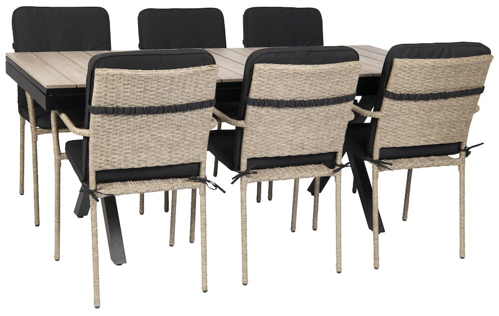 Utdragbart svart bord med sex rottingstolar och dynor.