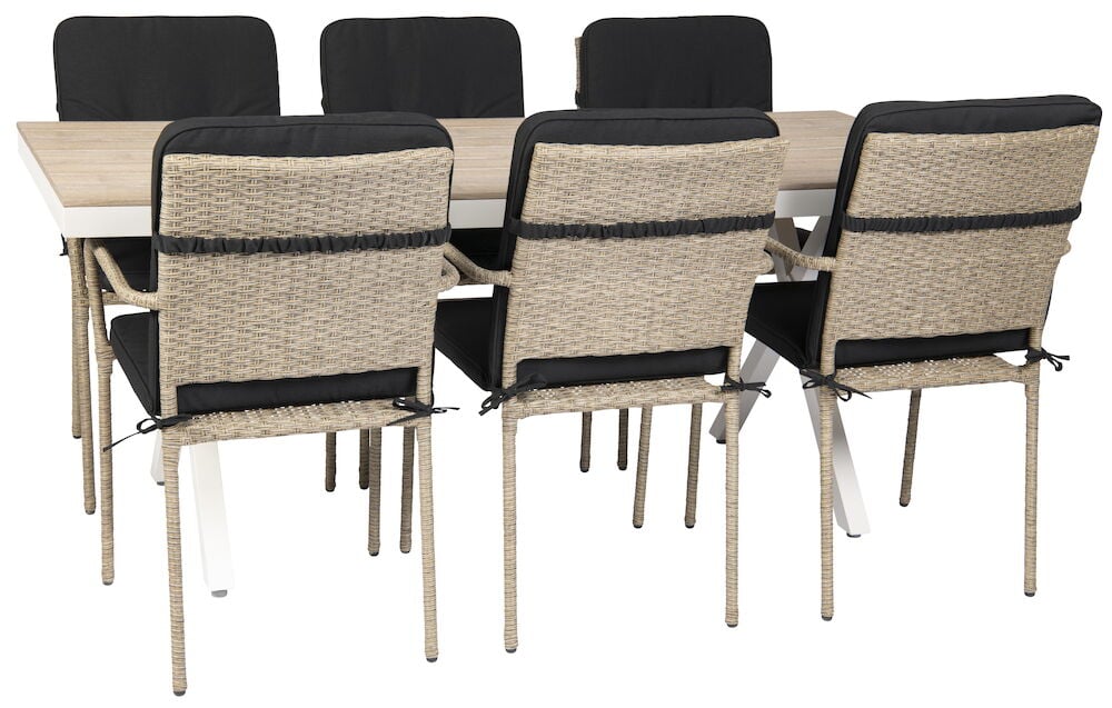 Rektangulärt vitt bord med sex stolar och svarta dynor.