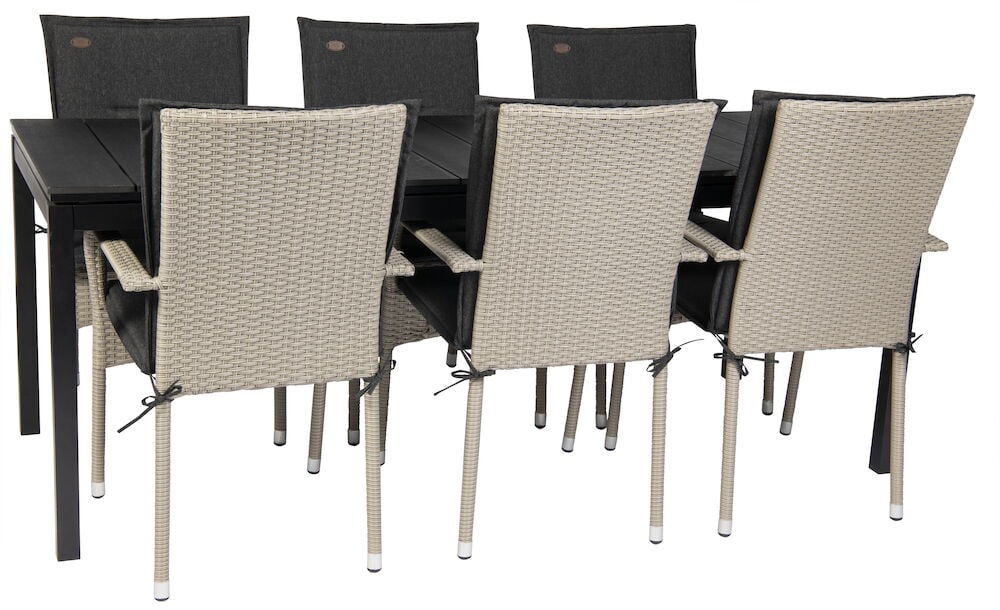 Svarta dynor på rottingstolar kring matbord.