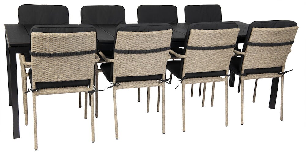 Svarta dynor på stolar runt rektangulärt matbord.