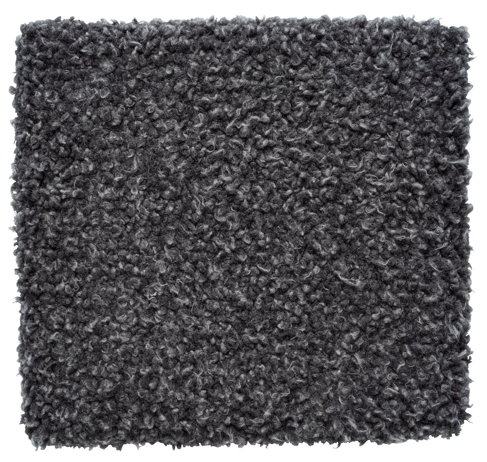 Tummanharmaa tekoturkismateriaalinen istuinpehmuste.