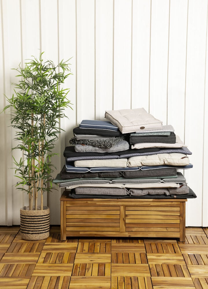 Hög rygg dyna i melerad grå på trälåda.