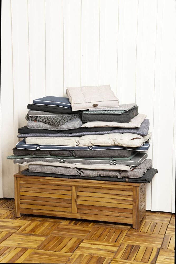 Flera staplade dynor på en träförvaringslåda.