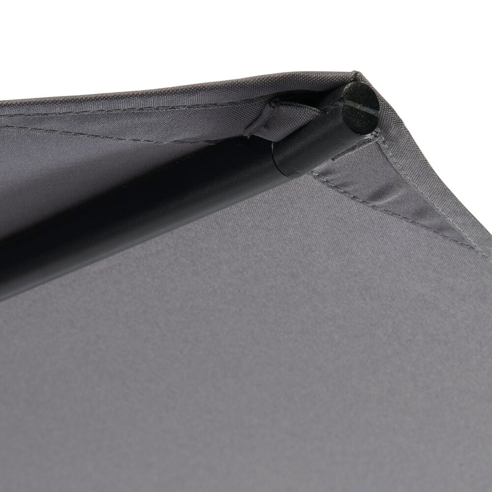 Närbild på grått parasolltyg och svart stång.