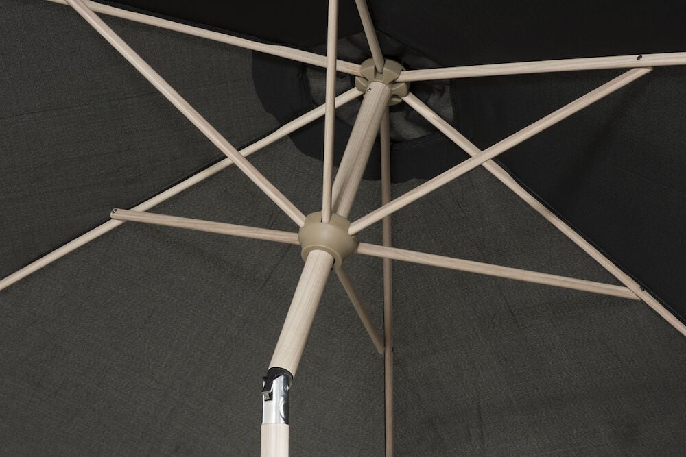 Aurinkovarjo mustalla kankaalla ja vaaleilla kylkiluilla.