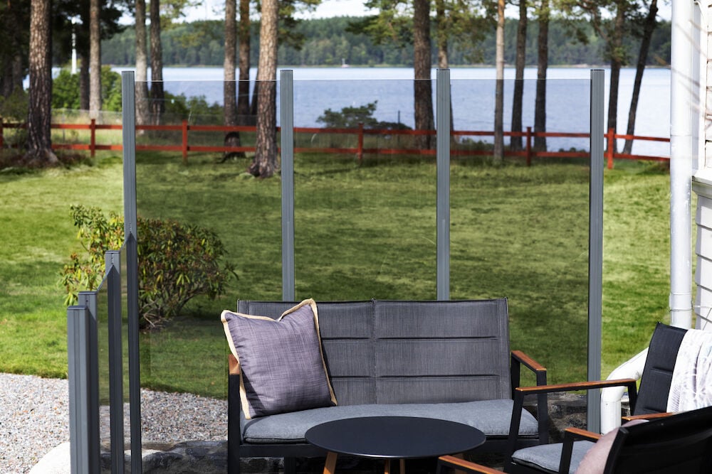 Harmaa alumiinipylväs terassilla, järvinäkymä taustalla.