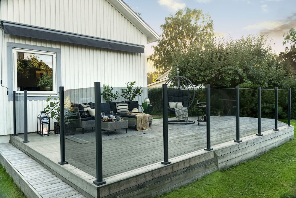 Glasräcke i rökgrått glas runt en altan.