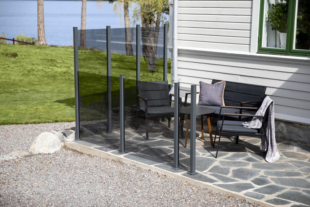 Glasgeländer in Rauchgrau um die Terrasse mit Gartenmöbeln.