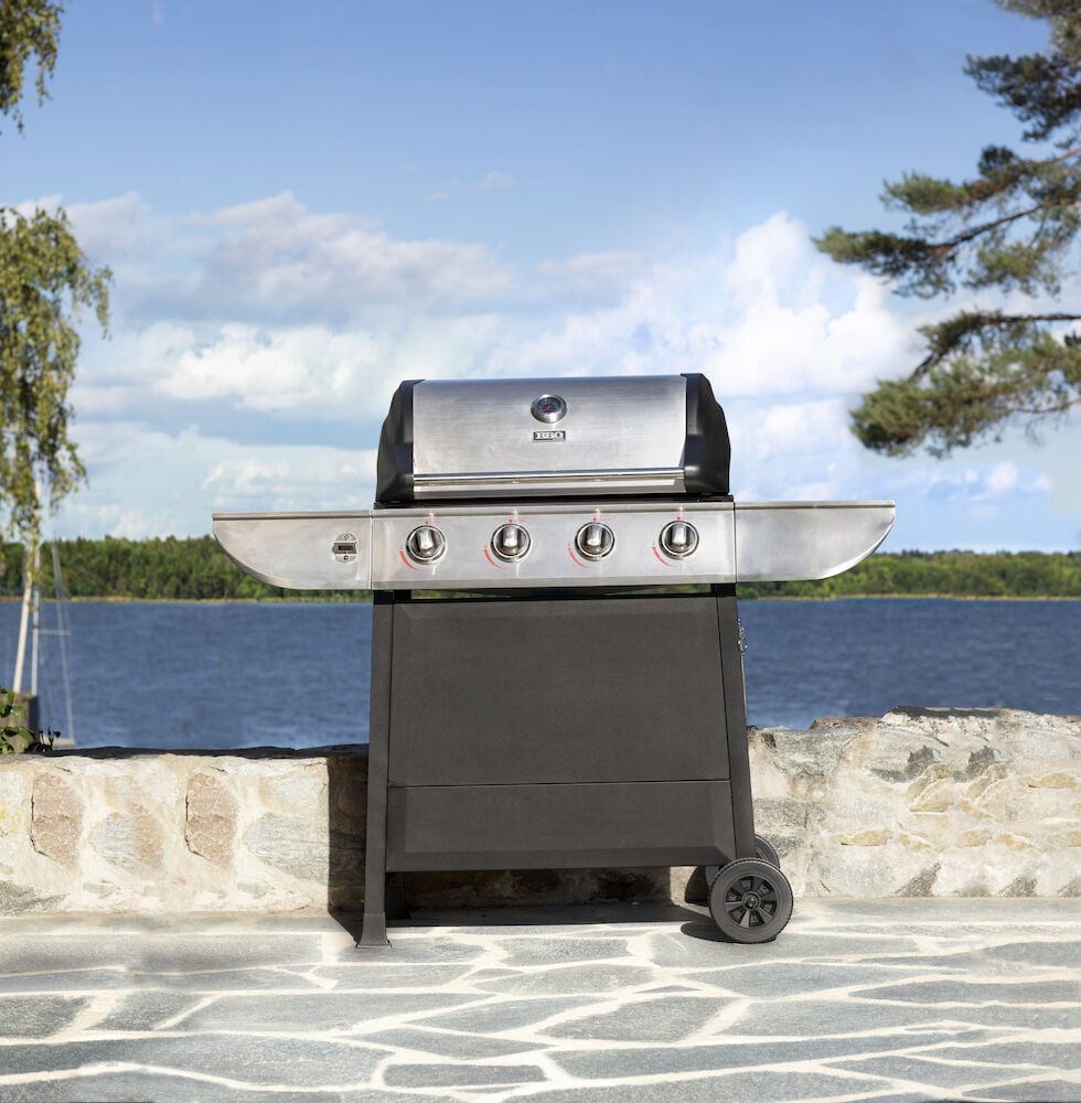Kaasugrilli neljällä polttimella kivipäällysteisellä terassilla.
