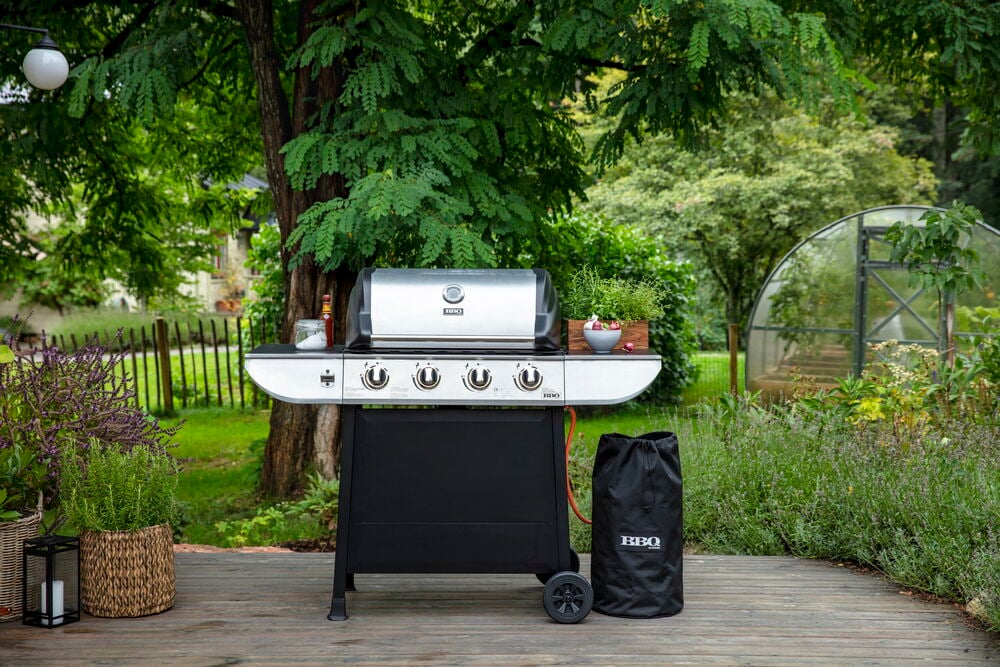 Propangasgrill Evolution GS 4 Brenner, silber und schwarz, mit schwarzer BBQ-Tasche auf Holzdeck.