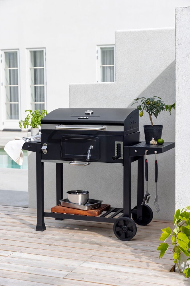 Svart Kullgrill Pampas XL med sidehyller, nedre hylle med brett og hengende verktøy.